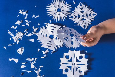 Beyaz kağıttan kesilmiş çeşitli Noel temalı kar tanelerinin arka planı, modaya uygun mavi arka plan 2020