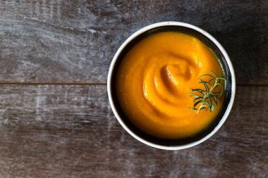 Kırsal ahşap bir masada sağlıklı kremalı balkabağı çorbası. Sonbahar balkabağı kremalı çorba biberiye ve kızarmış ekmek. Boşluğu kopyala