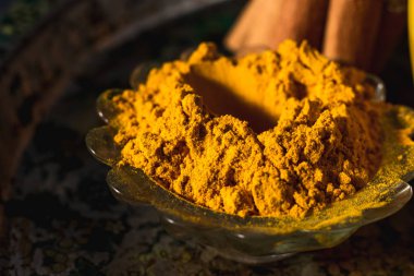 Koyu arkaplanda tarçın ve malzemelerle birlikte altın zerdeçal sütü.