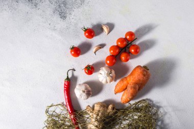 Tekrar kullanılabilir pamuklu bir çantada hafif bir arkaplanda faydalı sebzeler