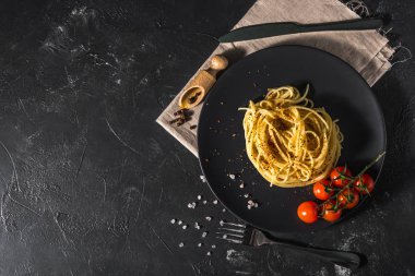 Domates soslu, peynirli ve koyu arkaplanda servis edilen sağlıklı baharatlı İtalyan spagettisi..