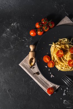 Domates soslu, peynirli ve koyu arkaplanda servis edilen sağlıklı baharatlı İtalyan spagettisi..