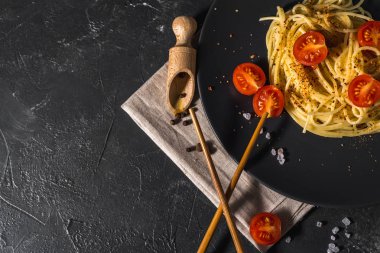 Domates soslu, peynirli ve koyu arkaplanda servis edilen sağlıklı baharatlı İtalyan spagettisi..