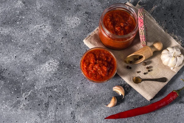 Gri beton arka planda geleneksel Meksika, Gürcü ve Arap harissa biber ezmesi. Faydalı baharatlı yemekler.  