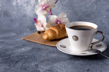 Kahve fincanı ve kahve çekirdekleri gri arka planda, mesajınız için yer var.