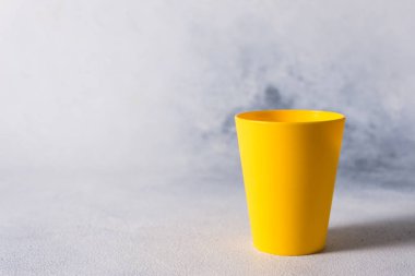 gri taş arkaplan plastik atık üzerinde renkli plastik bardaklar