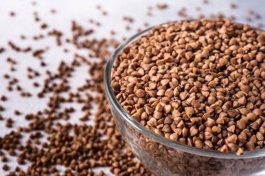 Gri arka planda izole edilmiş bir kasedeki sağlıklı karabuğday.