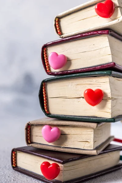 kırmızı plastik kalpler kitapların arka planında. Sevgililer Günü arkaplan tebrik kartı ile metin yeri