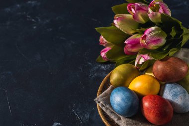 Çok renkli parlak paskalya yumurtaları. Karanlık bir arkaplan sembolünde paskalya yumurtaları. İsa yükseliyor. Copyspace yakın plan.