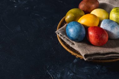 Çok renkli parlak paskalya yumurtaları. Karanlık bir arkaplan sembolünde paskalya yumurtaları. İsa yükseliyor. Copyspace yakın plan.