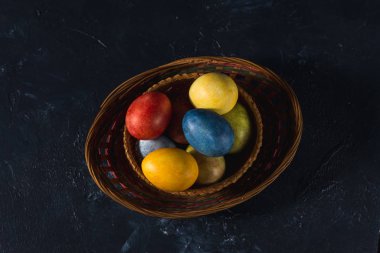 Çok renkli parlak paskalya yumurtaları. Karanlık bir arkaplan sembolünde paskalya yumurtaları. İsa yükseliyor. Copyspace yakın plan.