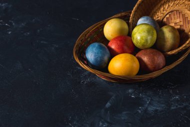 Çok renkli parlak paskalya yumurtaları. Karanlık bir arkaplan sembolünde paskalya yumurtaları. İsa yükseliyor. Copyspace yakın plan.