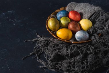 Çok renkli parlak paskalya yumurtaları. Karanlık bir arkaplan sembolünde paskalya yumurtaları. İsa yükseliyor. Copyspace yakın plan.