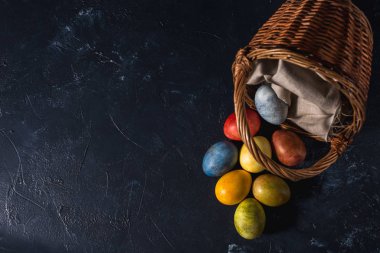 Çok renkli parlak paskalya yumurtaları. Karanlık bir arkaplan sembolünde paskalya yumurtaları. İsa yükseliyor. Copyspace yakın plan.