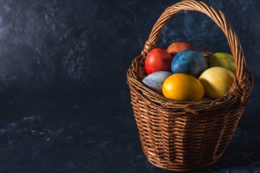 Çok renkli parlak paskalya yumurtaları. Karanlık bir arkaplan sembolünde paskalya yumurtaları. İsa yükseliyor. Copyspace yakın plan.