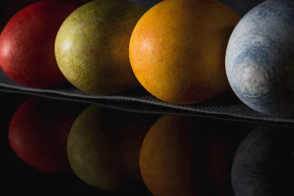 Çok renkli parlak paskalya yumurtaları. Karanlık bir arkaplan sembolünde paskalya yumurtaları. İsa yükseliyor. Copyspace yakın plan.