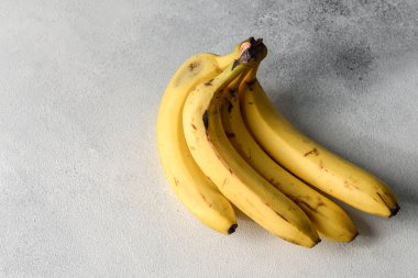 Çürümüş, çürümüş, çürümüş, beyaz muz. Gri arka planda izole edilmiş bir grup muz. Sarı muzlar