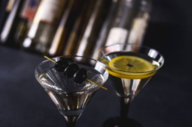 Siyah hayatlı sek martini. Martini bardağının içinde vermut kokteyli. Arkaplanda da martini bardakları. seçici odak