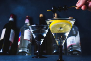 Sulu alkol kokteyli. Siyah hayatlı sek martini. Siyah arka planda martini bardağının içinde vermut kokteyli. seçici odak