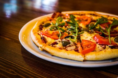 Teslimat tabağında sıcak pizza, hızlı teslimat saatleri, ziyan edilmiş fast food kavramı. İtalyan pizzası