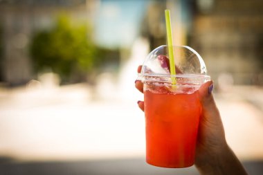 Kızın elinde soğuk yaz meyveli kokteyli var.