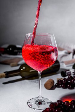 Kırmızı şarap dök. Bir şişe kırmızı şarap ve olgun üzümler. Metnin için boşluklu tasarım yap. Klasik stil