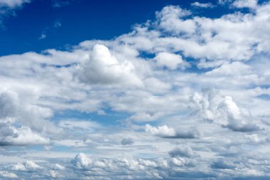 Yaz masmavi gökyüzü arka planı. Güneş ışığıyla aydınlatılan resim gibi bulutlar. Geniş gökyüzü