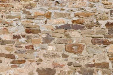 Antika taş bir duvarın dokusu. Eski kale taşından duvar dokusu. Arkaplan ya da doku olarak taş duvar.