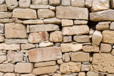 Antika taş bir duvarın dokusu. Eski kale taşından duvar dokusu. Arkaplan ya da doku olarak taş duvar.
