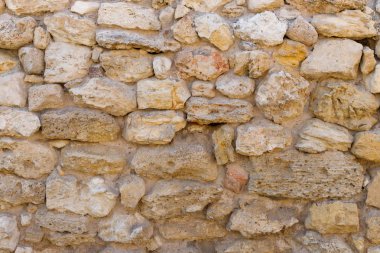 Antika taş bir duvarın dokusu. Eski kale taşından duvar dokusu. Arkaplan ya da doku olarak taş duvar.