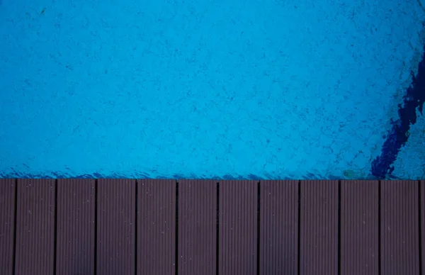 Blue swimming pool with teak wood flooring — Stock Photo, Image