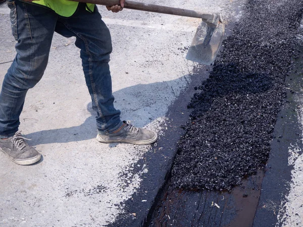 Trabajador utiliza compactador de placa vibratoria compactando asfalto en carretera — Foto de Stock