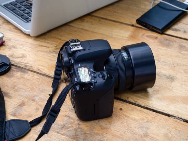 Dijital kamera, lens ve bilgisayar araçlarıyla ahşap fotoğrafçı bürosu masası
