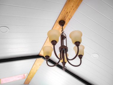 Klasik tarzda asılmış tavan lambası sıcak turuncu ton açık renk beton arka plan duvarı