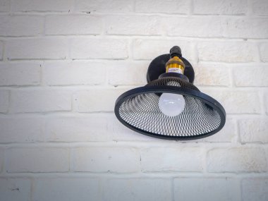 Klasik tarzda asılmış tavan lambası sıcak turuncu ton açık renk beton arka plan duvarı