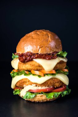 Siyah arka planda taze lezzetli bir burger. Boşluğu kopyala