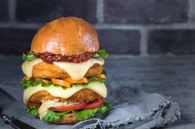 Ev yapımı tavuk burger ve kızarmış yumurta domatesli salatalık.