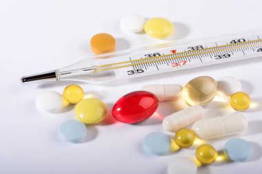 Beyaz arka planda haplar ve termometre. Grip salgını kavramı. Boşluğu kopyala.