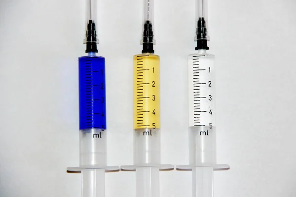 Three syringes were filled with different color fluids. Camera model Canon EOS 600D. Aperture f/5.6. Shutter speed 1/125 s. The focal length 120 mm.
