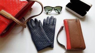 Kadın aksesuarları Deri eldivenler, beyaz kot pantolonlar, siyah güneş gözlüğü, cüzdan, mavi beyaz kot pantolon ve süveter, beyaz arka planda lüks moda kızları, şık konsept. 