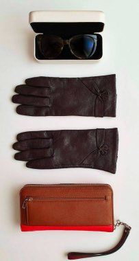 Kadın aksesuarları Deri eldivenler, beyaz kot pantolonlar, siyah güneş gözlüğü, cüzdan, mavi beyaz kot pantolon ve süveter, beyaz arka planda lüks moda kızları, şık konsept. 