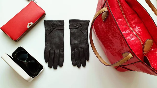 Kadın aksesuarları Deri eldivenler, beyaz kot pantolonlar, siyah güneş gözlüğü, cüzdan, mavi beyaz kot pantolon ve süveter, beyaz arka planda lüks moda kızları, şık konsept. 