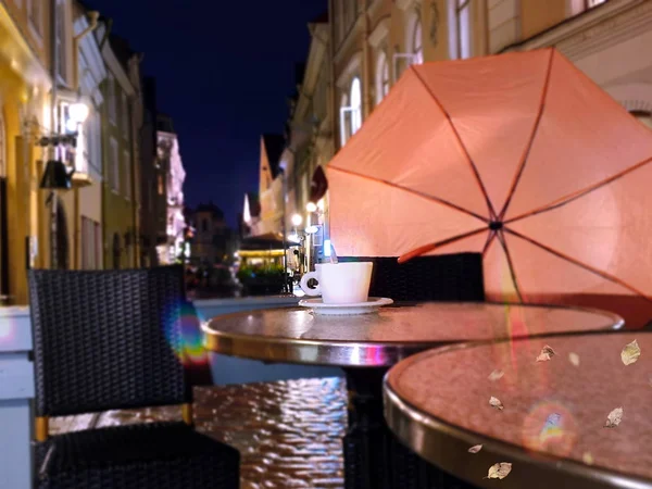 Street Cafe Autumn Rainy Evening  pink umbrella on old pavement   city light    blurring bokeh effect background