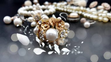 Mücevher kostüm mücevheri zümrüt opal inci inci vintage gümüş, altın küpeler siyah arka plan kozmetik çantasındaki kolye. 