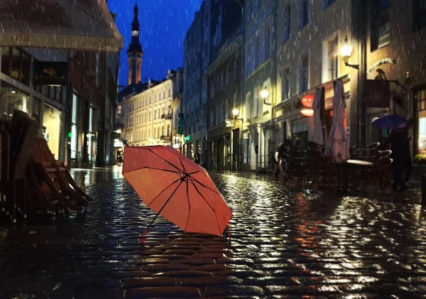 タリン旧市街光ピンク色の傘雨季通りの夜の光が都市の人々がヨーロッパでストリートカフェ休日旅行を歩くエストニアの都市パノラマ秋の夏の季節 — ストック写真