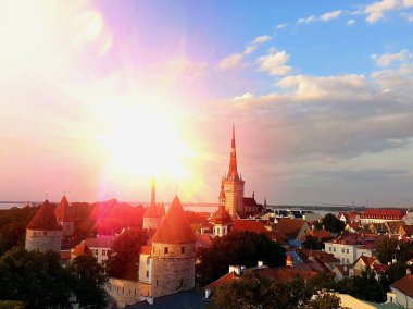 Eski Tallinn Kasabası 'nda romantik pembe günbatımı Tallinn' de güzel bir yaz akşamının manzarası insanlar güzel manzaranın tadını çıkarıyorlar, sokak kafesinde oturuyorlar, Avrupa 'da tatil yapıyorlar, ufukta ortaçağ kulesi var. , 