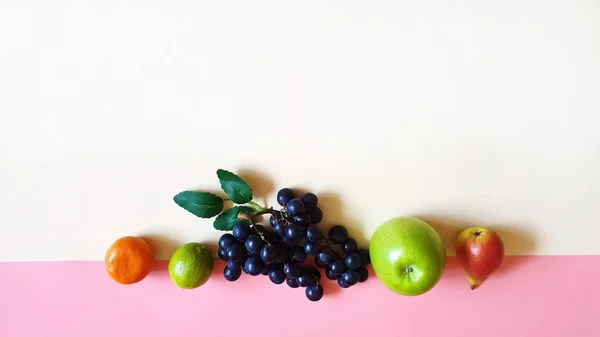 Fruits on background poster Fresh Eco Fruits Assortment  orange  lilac grape yellow  pear mandarin and green apple blue plate healthy fitness food diet  pink modern abstract concept background diet wishes quotes text  banner 