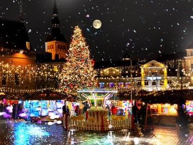 Christmas  Tallinn  marketplace In  old town square panorama   , full moon on night sky , tree light decoration , new year winter holiday in Europe blurred  light ,travel to Estonia,best  Christmas market in Europe 