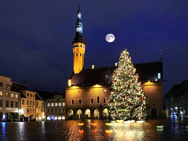 Tallinn  Christmas tree  In  old town square panorama   best  marketplace ,full moon on blue  night sky , tree light decoration , new year winter holiday in Europe blurred  light ,travel to Estonia,Rainy Christmas holiday in Europe