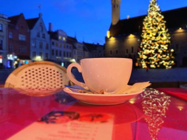 Tallinn 'in eski bir kasabasında, Avrupa' ya Noel tatili seyahatinde bir fincan kahve, Ortaçağ şehrinde akşam bulanıklığı 